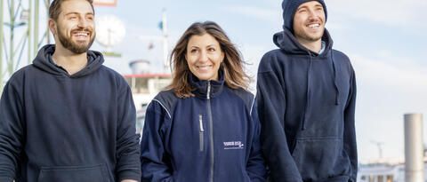 Mitarbeitende der Werft der Bodensee-Schiffsbetriebe lachen auf dem Werftgelände in Konstanz.