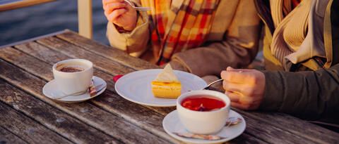 Paar im Herbst an Bord mit Tee und Kuchen