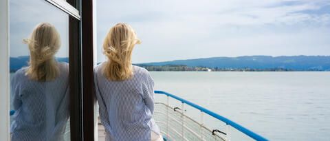 Frau an Bord schaut auf das Wasser