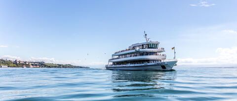 "MS Überlingen" fahrend auf dem Bodensee bei blauem Himmel. 