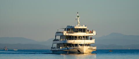 "MS Überlingen" fahrend auf dem Bodensee im Sonnenuntergang.