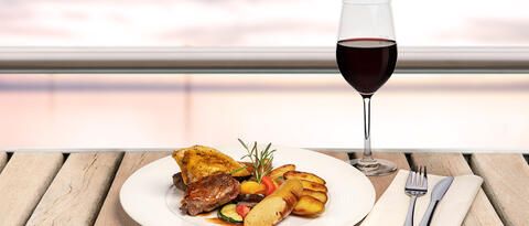 Leckerer Grillteller und ein Glas Rotwein auf einer Schifffahrt mit essen mit Blick auf den Bodensee. 