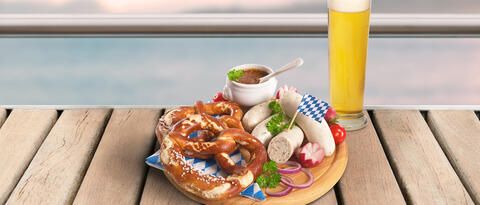 Ein Vesperbrett mit bayrischen Spezialitäten und ein Weißbier bei einer Schifffahrt mit Essen und Blick auf den Bodensee.