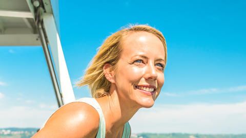 Frau genießt Fahrtwind und den Ausblick auf den Bodensee auf dem BSB-Schiff