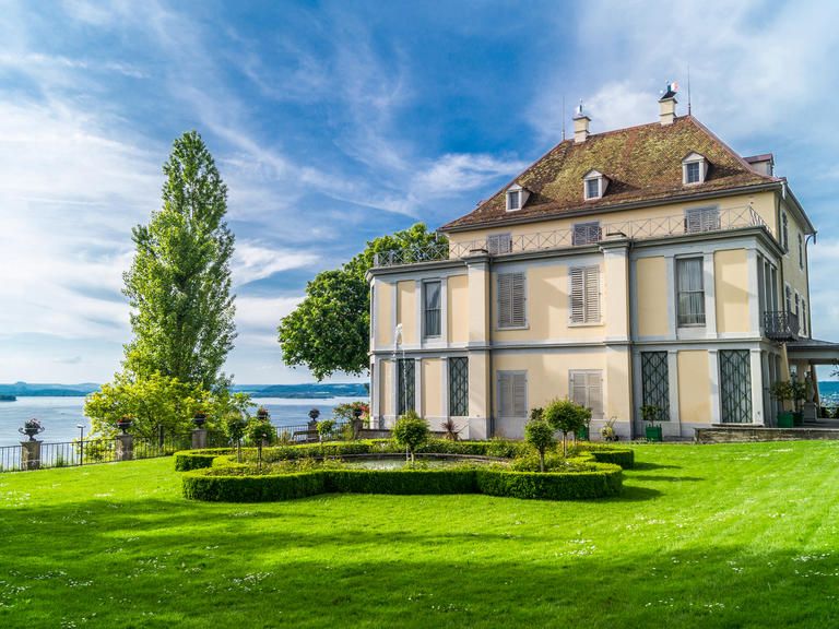 Blick auf das Schloss Arenenberg vor blauem Himmel.