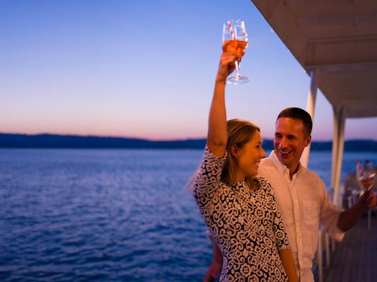 Paar feiert an einer Reling an Bord