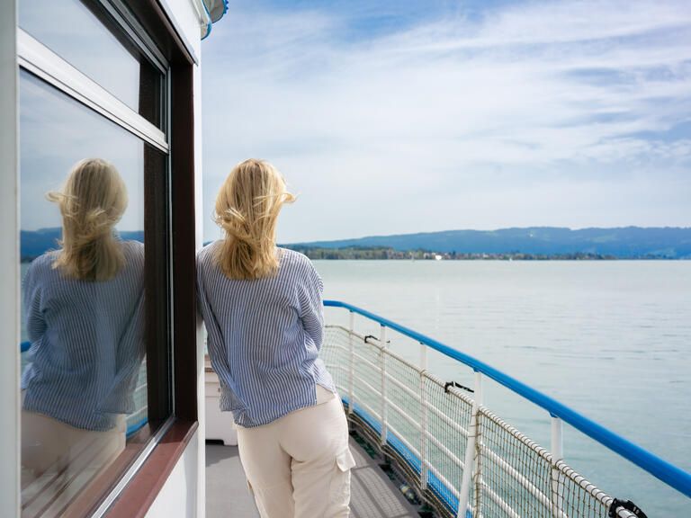 Frau an Bord schaut auf das Wasser