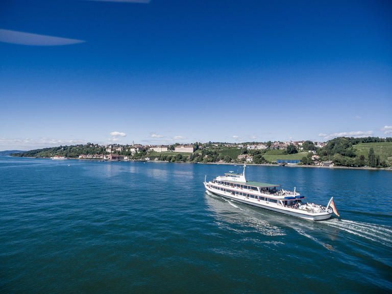 Schiff der Bodensee-Schifffahrt fährt auf dem Bodensee mit blauem Himmel.