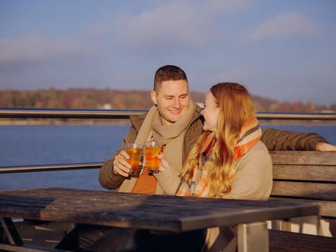 Paar im Herbst an Bord mit Getränk