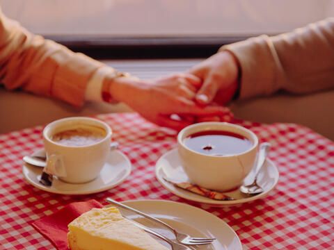 Paar im Herbst im Innenraum des Schiffes mit Kaffee und Kuchen