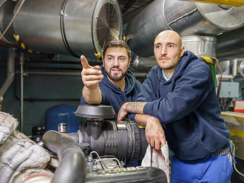 Elektriker mit Kollegen im Maschinenraum