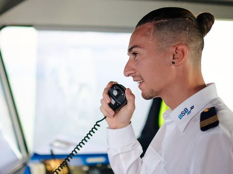 Schiffsführer spricht ins Mikrofon