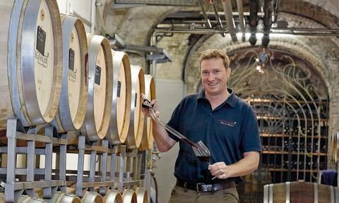 Mann füllt Glas mit Wein